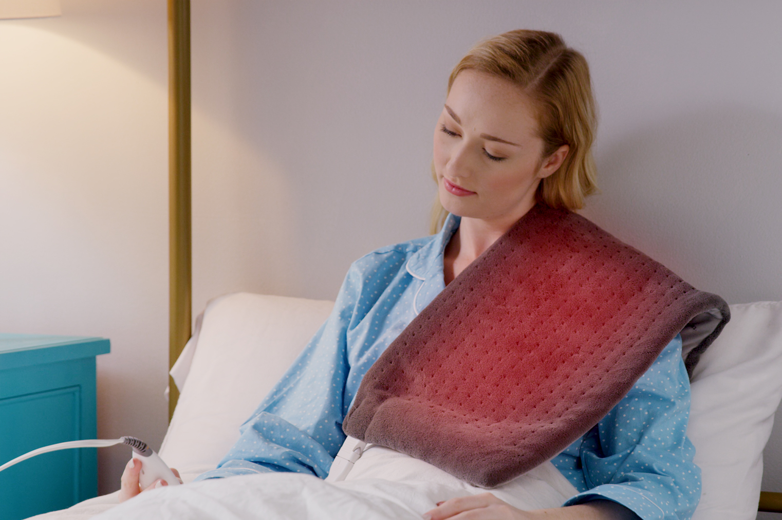 A woman wearing calming comfort heat pad on her shoulder